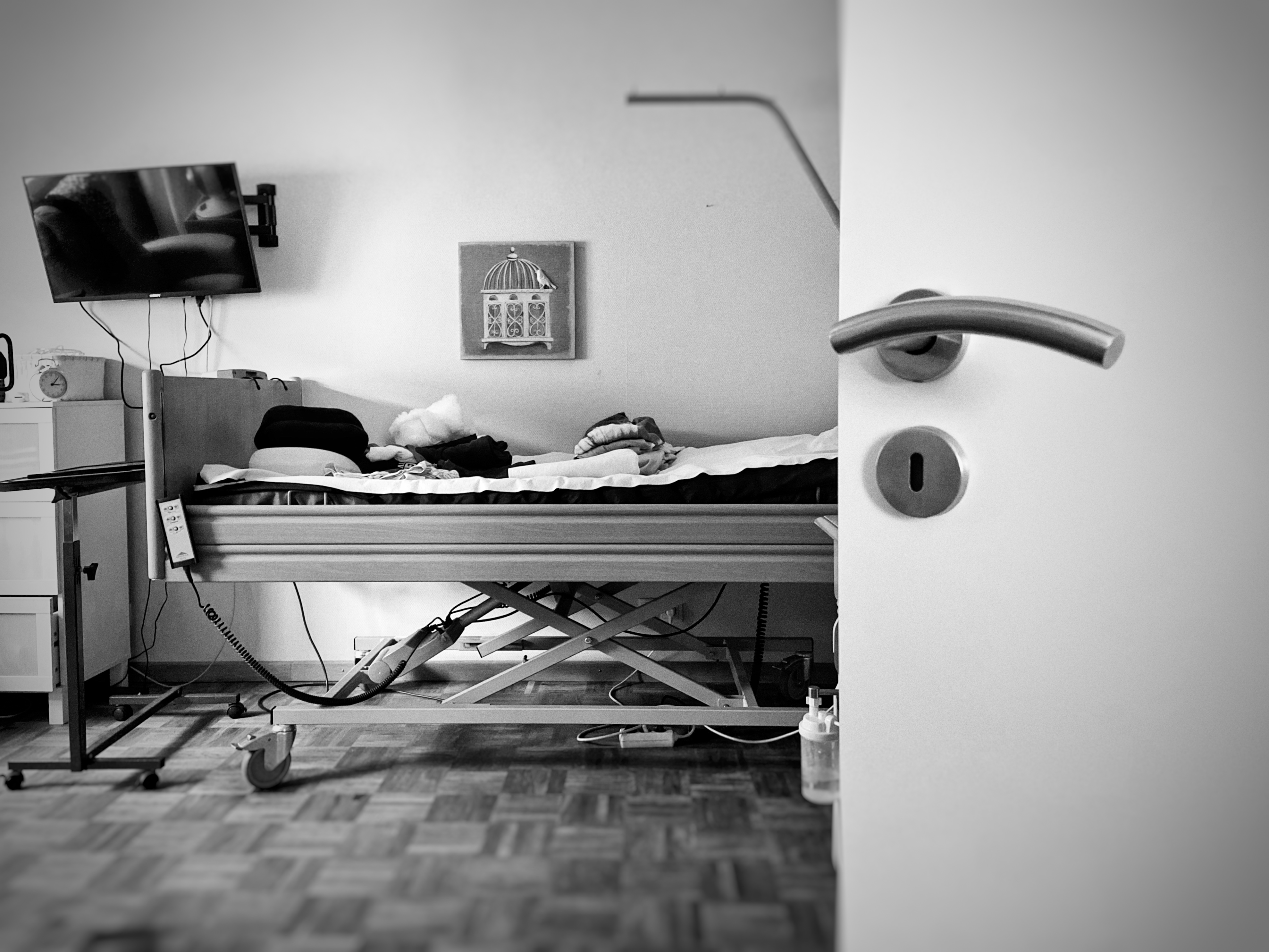 A quiet room seen through an open door, with an empty care bed